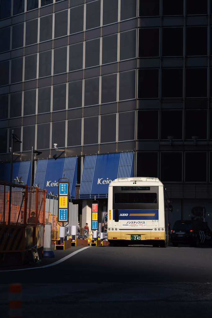 City bus driving past a modern building and construction.